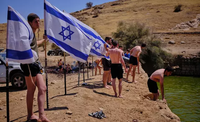 Israelis enjoy a day at an ancient archaeological site known as Herod's Pool, near the Israeli settlement of Petzael, which was filled with water earmarked for Palestinian farmland, in the occupied West Bank's Jordan Valley, on June 19, 2026. (AP Photo/Ohad Zwigenberg)