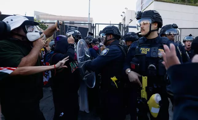 FILE - Protesters confront federal law enforcement agents outside the Metropolitan Detention Center on June 6, 2026, commemorating federal immigration raids and community protests one year ago in Los Angeles. (AP Photo/Jill Connelly, File)