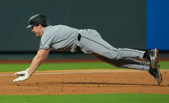 Chicago White Sox's Kyle Teel dives to third to advance on an RBI single by Miguel Vargas during the third inning of a baseball game against the Kansas City Royals, Wednesday, Sept. 23, 2026, in Kansas City, Mo. (AP Photo/Charlie Riedel)