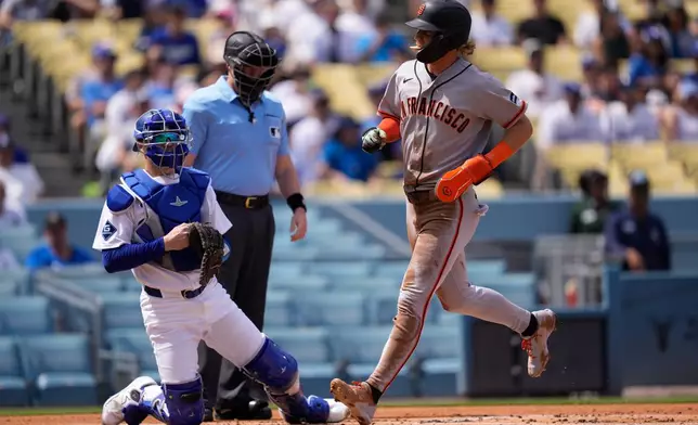 San Francisco Giants' Jonah Cox, right, scores on a single by Victor Bericoto as Los Angeles Dodgers catcher Hunter Feduccia kneels at the plate during the first inning of a baseball game against the Los Angeles Dodgers, Sunday, Sept. 20, 2026, in Los Angeles. (AP Photo/Mark J. Terrill)