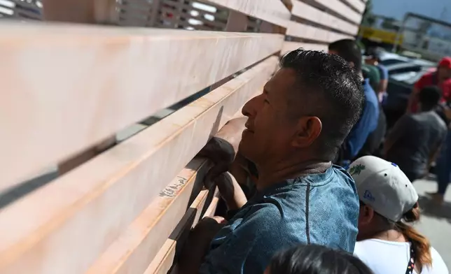 Relatives of crew members of the boat Maria Candelaria peer through a fence outside a police facility in Manta, Ecuador, Monday, Sept. 7, 2026, as they wait for the crew to return after the boat was intercepted by U.S. authorities on suspicion of alleged drug trafficking. (AP Photo/Ariel Ochoa)