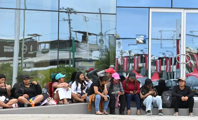 Women wait for information about the expected arrival of their relatives who were aboard the Maria Candelaria, a vessel intercepted two days prior by U.S. authorities on suspicion of alleged drug trafficking, outside a police station in Manta, Ecuador, Monday, Sept. 7, 2026. (AP Photo/Ariel Ochoa)
