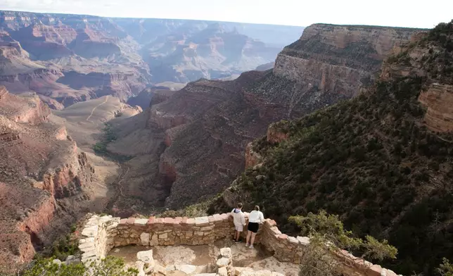 Tourists look down into the Grand Canyon off of the south rim, Monday, Aug. 31, 2026 at Grand Canyon National Park, Ariz. (AP Photo/Josh Biggs)