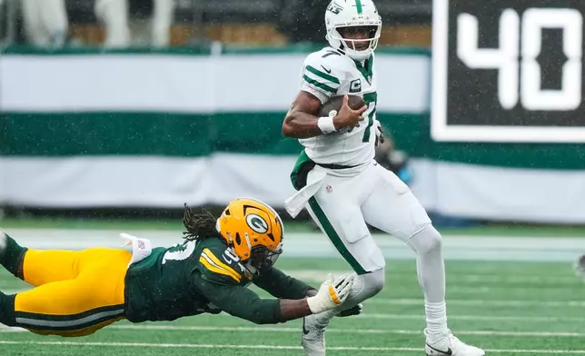 Green Bay Packers defensive end Brenton Cox Jr. (57) attempts to tackle New York Jets quarterback Geno Smith (7) during an NFL football game in East Rutherford, N.J., Sunday, Sept. 20, 2026. (AP Photo/Yuki Iwamura)
