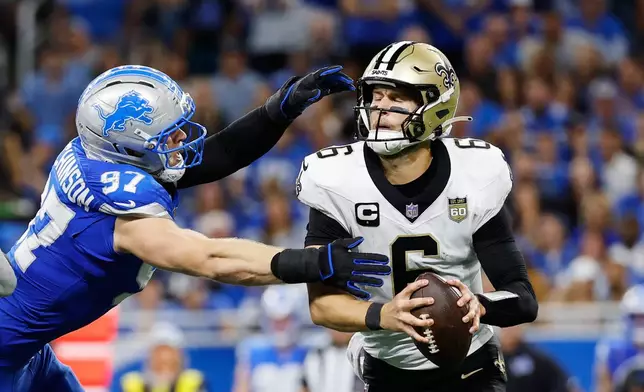 New Orleans Saints quarterback Tyler Shough (6) is sacked by Detroit Lions defensive end Aidan Hutchinson (97) in the second half of an NFL football game, Sunday, Sept. 13, 2026, in Detroit. (AP Photo/Rey Del Rio)