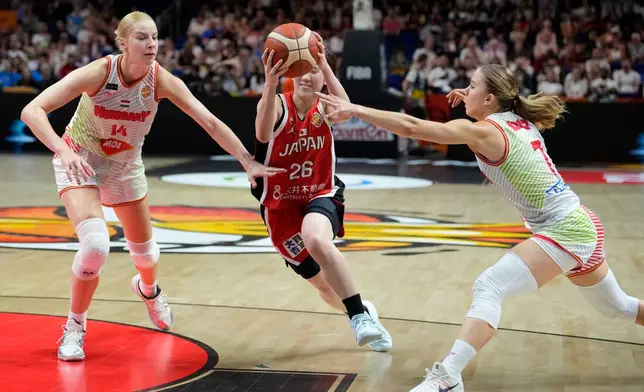 Japan's Kokoro Tanaka is challenged by Hungary's Dorka Juhasz, left, and Veronika Kanyasi during the Women's Basketball World Cup qualification playoff between Hungary and Japan in Berlin, Tuesday Sept. 8, 2026. (AP Photo/Ebrahim Noroozi)