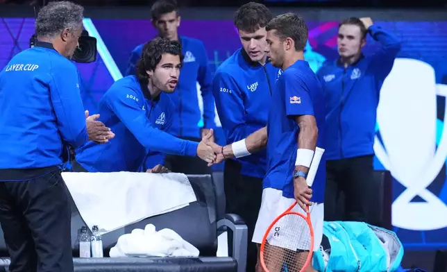 Team Europe's Flavio Cobolli is greeted by Carlos Alcaraz and team captain Yannick Noah during a break in his match against Team World's Learner Tien during the Laver Cup tennis tournament in London, Saturday, Sept. 26, 2026. (AP Photo/Maja Smiejkowska)