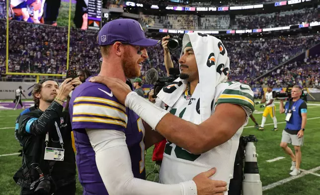 Minnesota Vikings quarterback Carson Wentz, left, and Green Bay Packers quarterback Jordan Love, right, greet each other after an NFL football game, Sunday, Sept. 13, 2026, in Minneapolis, Minn. (AP Photo/Bailey Hillesheim)