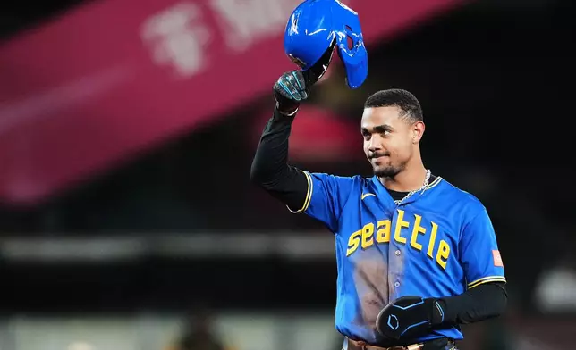 Seattle Mariners' Julio Rodríguez tips his cap after stealing second base, reaching a fifth consecutive season of 20 home runs and 20 stolen bases, during the eighth inning of a baseball game against the Athletics, Thursday, Sept. 3, 2026, in Seattle. (AP Photo/Lindsey Wasson)