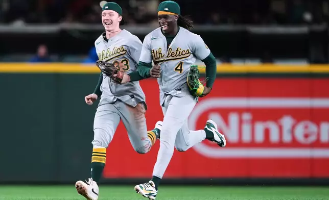 Athletics center fielder Henry Bolte (33) and right fielder Lawrence Butler (4) run to the infield while celebrating a win over the Seattle Mariners in a baseball game, Thursday, Sept. 3, 2026, in Seattle. (AP Photo/Lindsey Wasson)