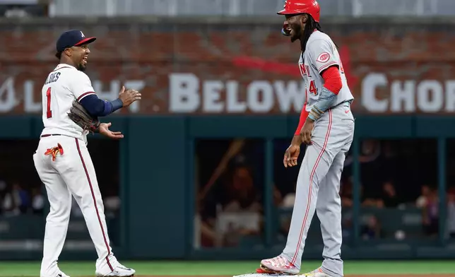 Cincinnati Reds' Elly De La Cruz (44) jokes with Atlanta Braves second baseman Ozzie Albies (1) during a replay challenge of De La Cruz's steal of second base in the first inning of a baseball game, Tuesday, Sept. 22, 2026, in Atlanta. (AP Photo/Erik S. Lesser)