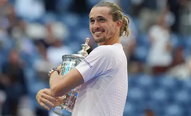 Alexander Zverev, of Germany, poses with the trophy after he won the men's singles final of the U.S. Open tennis championships against Ben Shelton, of the United States, Sunday, Sept. 13, 2026, in New York. (AP Photo/Kirsty Wigglesworth)