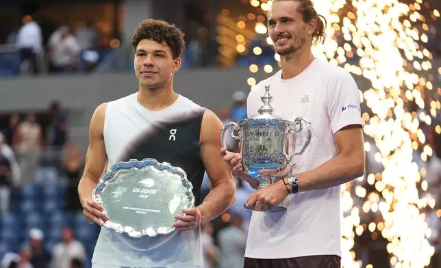Ben Shelton, of the United States, left, and Alexander Zverev, of Germany, right, pose for a photo together with their trophies after Zverev won the men's singles final of the U.S. Open tennis championships Sunday, Sept. 13, 2026, in New York. (AP Photo/Frank Franklin II)