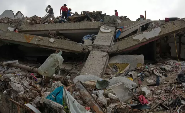 FILE - Workers clear rubble from an O-P-P housing tower that was built as part of a government program, after it collapsed during twin earthquakes in La Guaira, Venezuela, July 22, 2026. (AP Photo/Ariana Cubillos, File)