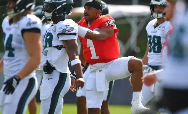 Philadelphia Eagles quarterback Jalen Hurts (1) warms up with teammates during a joint NFL football practice with the New England Patriots, Thursday, Aug. 20, 2026, in Foxborough, Mass. (AP Photo/Steven Senne)