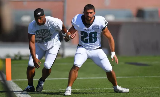 Philadelphia Eagles running backs Saquon Barkley, left, and Will Shipley (28) perform field drills during a joint NFL football practice with the New England Patriots, Thursday, Aug. 20, 2026, in Foxborough, Mass. (AP Photo/Steven Senne)