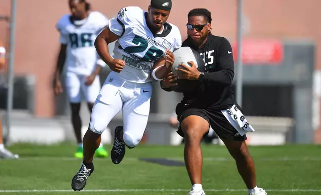 Philadelphia Eagles running back Saquon Barkley, center, performs field drills during a joint NFL football practice with the New England Patriots, Thursday, Aug. 20, 2026, in Foxborough, Mass. (AP Photo/Steven Senne)