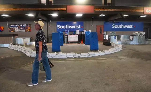 A man walks past a closed ticket counter for Southwest Airlines lined with sandbags at Hilo International Airport as Hurricane Nolo sits nearby Friday, Sept. 25, 2026, in Hilo, Hawaii. (AP Photo/Gregory Bull)