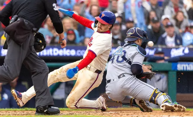 Philadelphia Phillies' Bryson Stott is safe at home before Tampa Bay Rays catcher Nick Fortes (40) can make the in the fifth inning of a baseball game, Sunday, Sept. 27, 2026, in Philadelphia. (AP Photo/Laurence Kesterson)