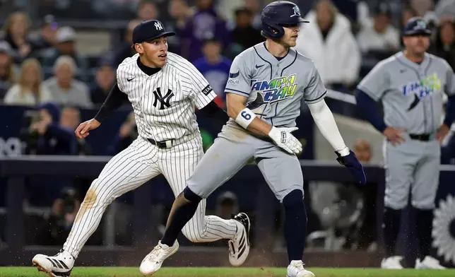 Tampa Bay Rays' Taylor Walls, front right, is tagged out by New York Yankees shortstop George Lombard Jr., left, in a rundown during the eighth inning of a baseball game Thursday, Sept. 24, 2026, in New York. (AP Photo/Adam Hunger)