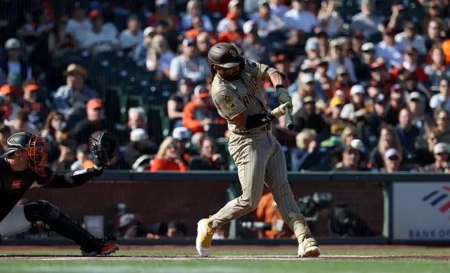 San Diego Padres' Fernando Tatis Jr., right, hits a single in front of San Francisco Giants catcher Andrew Knizner, left, during the first inning of a baseball game in San Francisco, Sunday, Sept. 13, 2026. (AP Photo/Jed Jacobsohn)