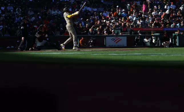 San Diego Padres' Jackson Merrill, front right, watches his two-run double in front of San Francisco Giants catcher Andrew Knizner, second from front left, during the first inning of a baseball game in San Francisco, Sunday, Sept. 13, 2026. (AP Photo/Jed Jacobsohn)