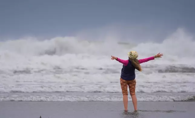 Brenda Malloy enjoys a nor'easter storm, Friday, Sept. 25, 2026, in Gloucester, Mass. (AP Photo/Robert F. Bukaty)