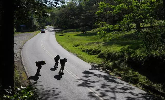 Skateboarders Edgar Lopez, left, Edison Bogado, center, and Raul Vysokolan train in the Mbatovi hills near Paraguari, Paraguay, Sunday, Sept. 20, 2026. (AP Photo/Jorge Saenz)