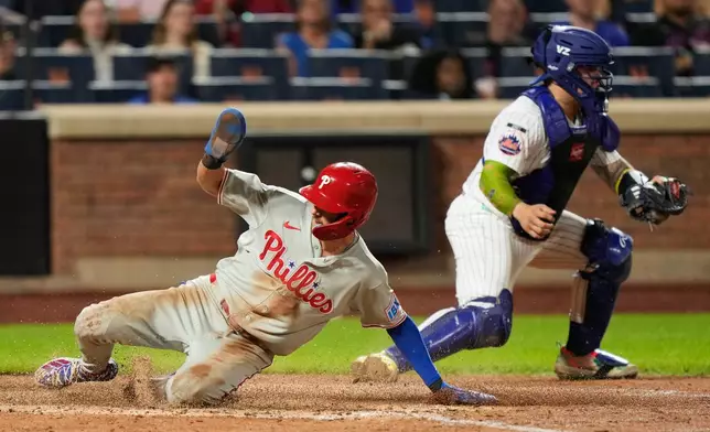Philadelphia Phillies' Trea Turner, left, slides home past New York Mets catcher Francisco Alvarez on a sac fly hit by Luis Arraez during the seventh inning of a baseball game, Thursday, Sept. 17, 2026, in New York. (AP Photo/Seth Wenig)
