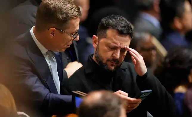 Ukraine's President Volodymyr Zelenskyy, right, looks at a smart phone as he attends the 81st session of the United Nations General Assembly at United Nations headquarters, Tuesday, Sept. 22, 2026. (AP Photo/Seth Wenig)
