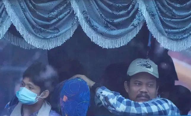 Myanmar nationals look out from a bus in Manjung, Perak state of Malaysia, on Tuesday, Sept. 29, 2026. (AP Photo/Vincent Thian)
