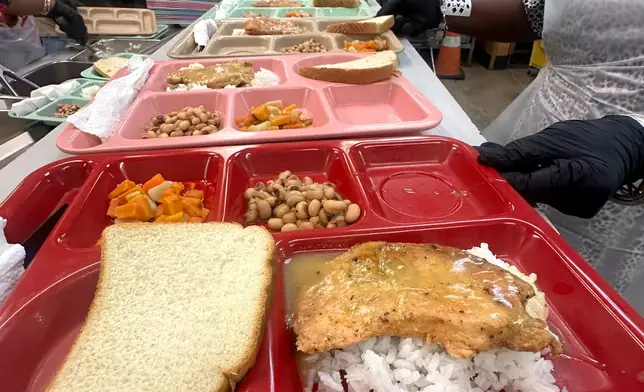Hot lunch trays with chicken, gravy, rice and vegetables are ready to be served at Christian Service, Tuesday, Aug. 25, 2026, in Shreveport, La. (AP Photo/Lisa Mascaro)