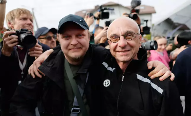 Dzmitry Navazhylau, right, one of the released Belarusian prisoners, is welcomed by his colleagues upon his arrival in Vilnius, Lithuania, Wednesday, Sept. 16, 2026. (AP Photo/Mindaugas Kulbis)