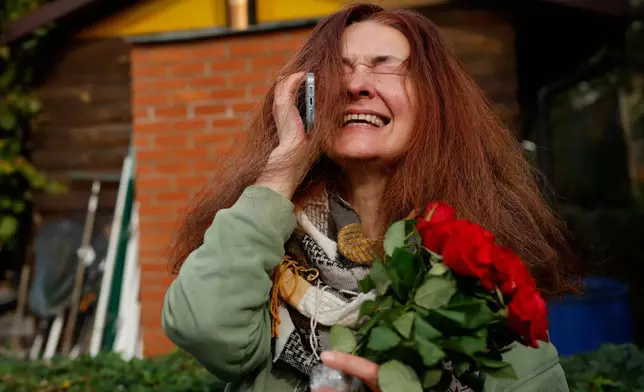 Tatsiana Kouzina, one of the released Belarusian prisoners reacts as she speaks on the phone upon her arrival in Vilnius, Lithuania, Wednesday, Sept. 16, 2026. (AP Photo/Mindaugas Kulbis)