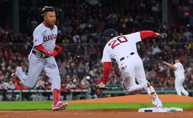 Cleveland Guardians' José Ramírez, left, dashes down the first base line as Boston Red Sox's Nick Sogard (20) steps away from the base on a single during the third inning of a baseball game, Thursday, Sept. 24, 2026, in Boston. (AP Photo/Charles Krupa)