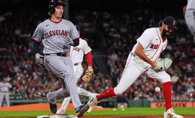 Cleveland Guardians' Chase DeLauter, left, reaches first base on a fielding error by pitcher Raymond Burgos, right, during the ninth inning of a baseball game, Thursday, Sept. 24, 2026, in Boston. (AP Photo/Charles Krupa)