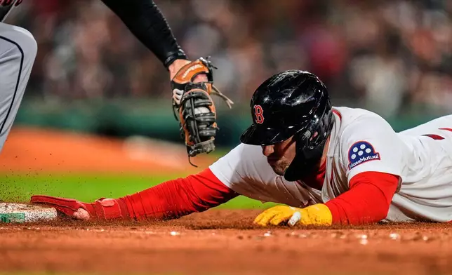 Boston Red Sox's Caleb Durbin dives back safely to first on a pick off attempt, beating a tag by Cleveland Guardians' David Fry, during the seventh inning of a baseball game, Thursday, Sept. 24, 2026, in Boston. (AP Photo/Charles Krupa)