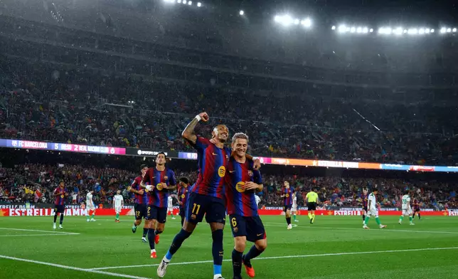 Barcelona's Raphinha celebrates with Gavi, right, after scoring his side's fifth goal from the penalty spot during a Spanish La Liga soccer match between Barcelona and Racing de Santander in Barcelona, Spain, Wednesday, Sept. 16, 2026. (AP Photo/Joan Monfort)