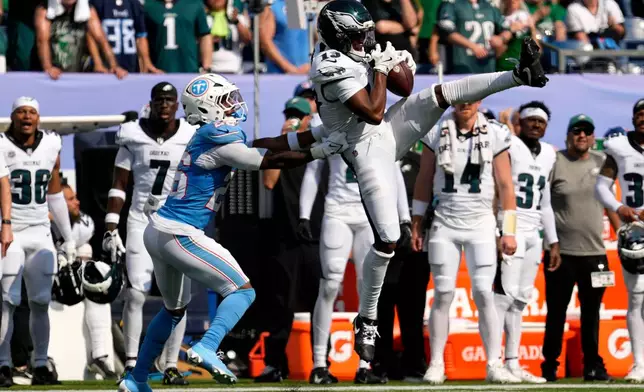 Philadelphia Eagles wide receiver Dontayvion Wicks (13) catches a pass over Tennessee Titans cornerback Marcus Harris (26) during the second half of an NFL football game, Sunday, Sept. 20, 2026, in Nashville, Tenn.(AP Photo/George Walker IV)