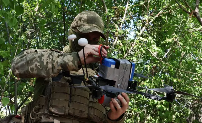 In this photo provided by Ukraine's 65th Mechanized Brigade press service, a Ukrainian soldier prepares an FPV drone to fire towards Russian positions in Zaporizhzhia region, Ukraine, Saturday, Sept. 19, 2026. (Andriy Andriyenko/Ukraine's 65th Mechanized Brigade via AP)