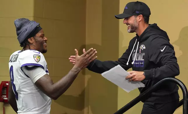 Baltimore Ravens head coach Jesse Minter shakes hands with Lamar Jackson after an NFL football game Sunday, Sept. 13, 2026, in Indianapolis. (AP Photo/Jeff Roberson)