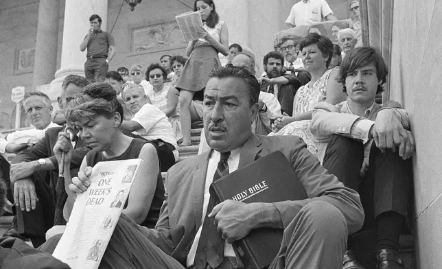 FILE - Rep. Adam Clayton Powell, D-N.Y., sits with Vietnam War protesters on the steps of the Capitol in Washington, on June 25, 1969. (AP Photo/Bob Daugherty, File)