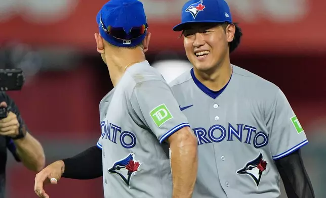 Toronto Blue Jays' Andres Gimenez, left, and Kazuma Okamoto celebrate after their baseball game against the Kansas City Royals, Saturday, Sept. 5, 2026, in Kansas City, Mo. (AP Photo/Charlie Riedel)