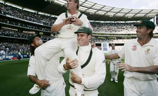 FILE - Australia's Shane Warne, second left, is lifted by teammates Andrew Symonds, left, and Matthew Hayden after Australia beat England on the third day of the Boxing Day test at the Melbourne Cricket Ground in Melbourne, Australia, on Dec. 28, 2006. (AP Photo/Rick Rycroft, File)