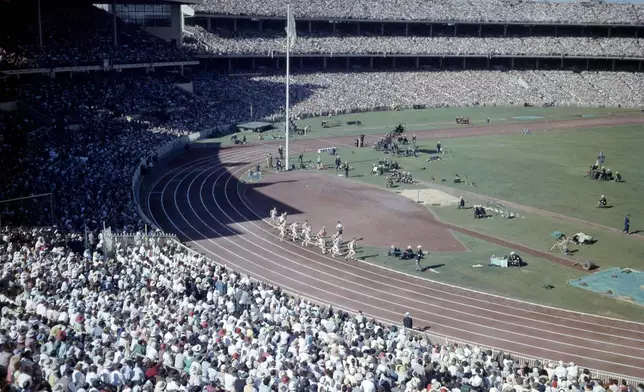 FILE - An overall view of crowds and athletes in the Olympic Stadium, in Melbourne, Australia, during the opening ceremony of XVI Olympic Games, Nov. 22, 1956. (AP Photo, File)
