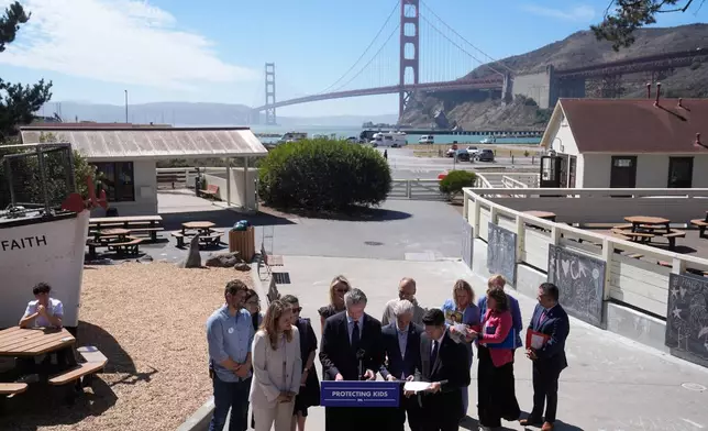 California Gov. Gavin Newsom, bottom center, signs bills at the Bay Area Discovery Museum, Thursday, Sept. 10, 2026, in Sausalito, Calif. (AP Photo/Jeff Chiu)