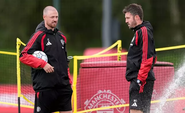 Manchester United manager Michael Carrick, right, speaks with Jonny Evans during a training session at Carrington Training Centre in Manchester, England, Wednesday, Sept 9, 2026. (Peter Byrne/PA via AP)