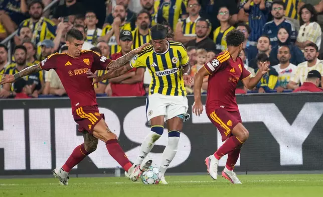 Fenerbahce's Archie Brown, centre, challenges for the ball with Roma's Gianluca Mancini, left, and Roma's Devyne Rensch during the Champions League opening phase soccer match between Fenerbahce and Roma in Istanbul, Turkey, Thursday, Sept. 10, 2026. (AP Photo/Khalil Hamra)