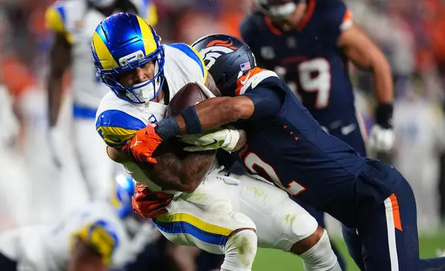 Los Angeles Rams running back Dean Connors, left, is tackled by Denver Broncos cornerback Pat Surtain II during the first half of an NFL football game Sunday, Sept. 27, 2026, in Denver. (AP Photo/Jack Dempsey)
