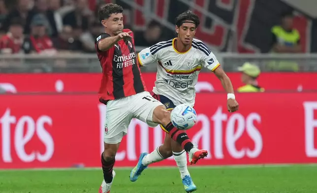 AC Milan's Christian Pulisic, left, battles for the ball with Lecce's Youssef Maleh during the Serie A soccer match between AC Milan and Lecce, in Milan, Italy, Sunday, Sept. 20, 2026. (AP Photo/Antonio Calanni)